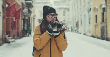 Karlı kış şehirde etrafa güzel genç kız içecekler kahve