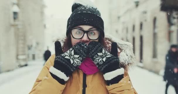 Surprised young pretty girl looking at the camera isolated on the winter background — Stock Video