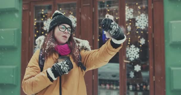 Mutlu kız kış şehirde bir selfie yapar. Kız selfie bir kış ve donmuş şehir arka planı yapar — Stok video