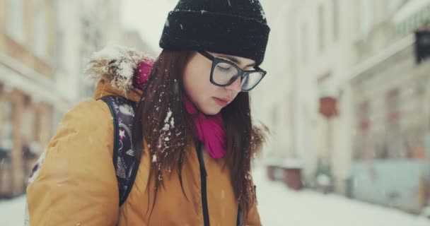 Kadın trendy kıyafeti yerel kafe, onu telefonla metinleri tarafından geçen kış City browsing belgili tanımlık enterne yürür. Online harita, gps kullanarak. — Stok video