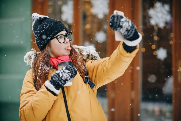 Aantrekkelijk meisje in glazen maakt selfie op haar smartphone. Vrouw maakt foto's op mobiele telefoon. Zou overal. Een meisje in lichte kleding — Stockfoto