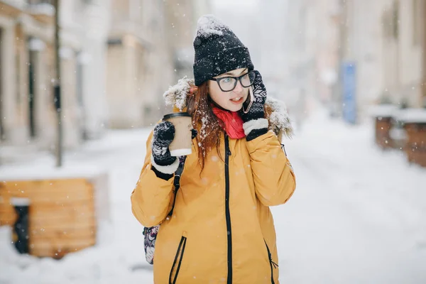 Meisje koffie drinken en praten over de telefoon buiten in de winter — Stockfoto