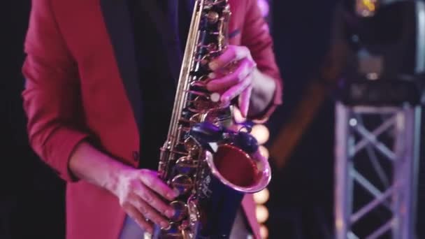 Saxofonist i röd jacka spela på gyllene saxofon. Liveframträdande. — Stockvideo