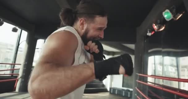 Boxer schlägt Boxsack in Turnhalle in Zeitlupe junger Mann, der drinnen trainiert. starker Athlet im Fitnessstudio. Sportkonzept — Stockvideo