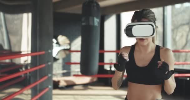 Joven mujer atractiva boxeo en VR 360 entrenamiento de auriculares para patear en la realidad virtual — Vídeo de stock