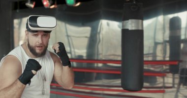 Kaslı adam Vr gözlük ve boks eldivenleri kameraya doğru yumruk atma