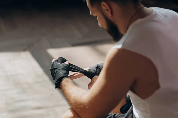 Hombre boxeador envolviendo manos preparándose para una pelea. Manos de embalaje para guantes de boxeo — Foto de Stock