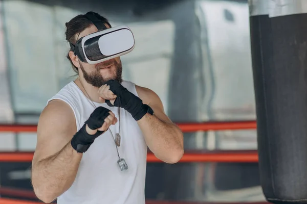 Boxer man with vr glasses fighting in simulated virtual reality