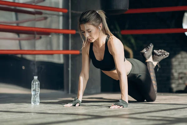 Fille sportive effectuant push-ups sur le sol. Jeune femme attrayante — Photo