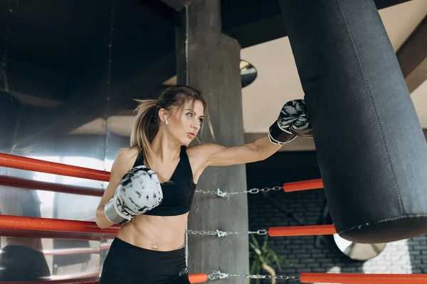 Boxeador atleta entrenamiento boxeo saco de boxeo disfrutando de ejercicio intenso musulmán — Foto de Stock