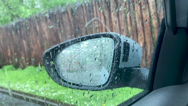 Gotas de lluvia en la ventana lateral y el espejo del coche — Vídeos de Stock