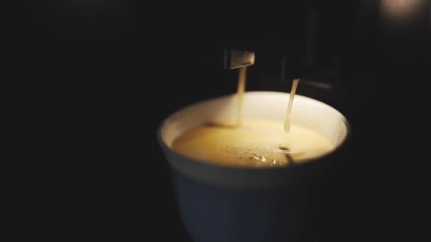 Closeup de uma máquina de café de aço inoxidável profissional derramando café expresso aromático acabado de fazer em uma xícara de cerâmica branca. Máquina automática de café preparando café expresso — Vídeo de Stock