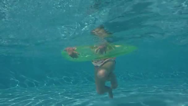 Felice bambina che gioca con anello gonfiabile colorato nella piscina all'aperto nella calda giornata estiva — Video Stock