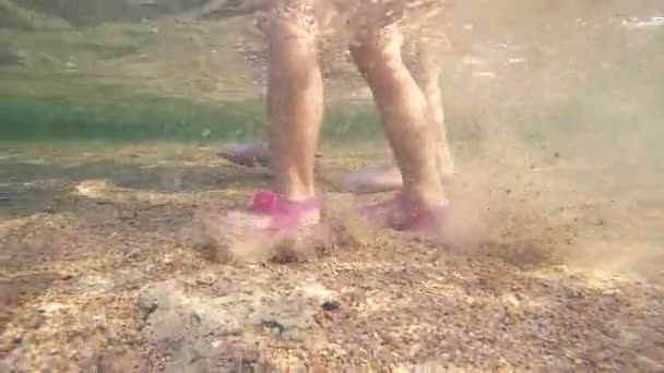 Piernas femeninas con dedos de los pies rosa manicura caminando bajo el agua. Punto de vista de la mujer caminando en el agua de mar en la playa de arena. Pasos submarinos de una niña en el agua poco profunda en un fondo marino arenoso — Vídeos de Stock