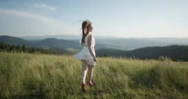 Genç güzel kız gülümseyerek ve başarı kutluyor dağın tepesinde ellerini kaldırarak