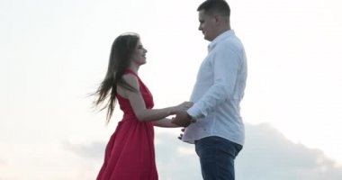 Mutlu çift kucaklama duruyor ve güzel gün batımında birbirlerini öper