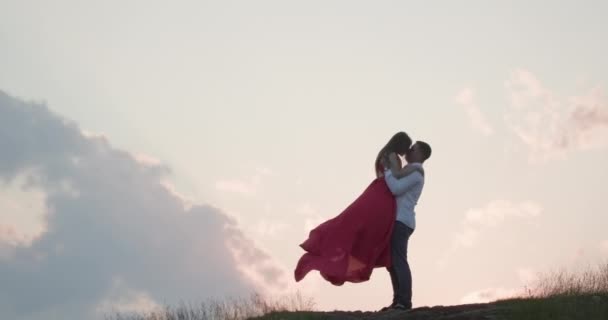 Romantikus pár megcsókolta egymást. Gyönyörű romantikus férfi és a nő ölelés, és osztozik egy csókot a naplementében a szabadban — Stock videók