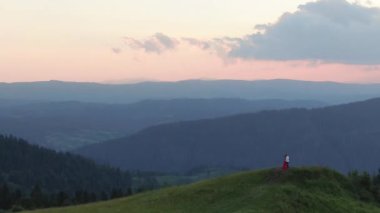 Dağda birbirlerini öpen çift. Aşık mutlu çift birbirlerini öper ve okşar. Yeşil yoğun dağda birbirlerini öpen, kucaklayan genç sevimli çift Amazing havadan görünümü