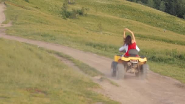 La coppia e 'in sella a un quad. Giovane coppia di turisti sta godendo di un bellissimo paesaggio di montagna al tramonto — Video Stock