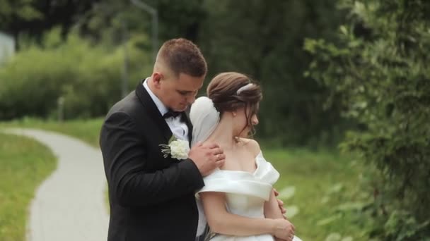 Bröllopspar promenad. Vackra unga paret bara in från kyrkan — Stockvideo