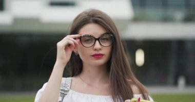 Gözlük çekici genç kadın iyi ruh hali rahat takım lideri veya iş kadını uzun saçlı mutlu esmer kadın yakın yüzü