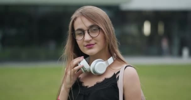 Close-up portret van aantrekkelijke vrouw met zonnebril ziet er vertrouwen in camera dragen van lederen jas — Stockvideo