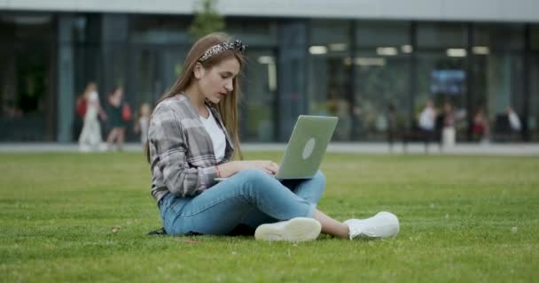 Studentin arbeitet im Park am Laptop. — Stockvideo