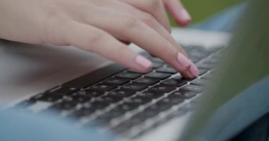 Yeşil taze çim üzerinde otururken onu dizüstü bilgisayarda kadın yazma metin. Freelancer, blogger, gazeteci, öğrenci kavramı. Modern teknolojiler. Görünümü kapat