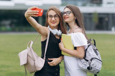 Akıllı telefonda selfie selfie selfie selfie selfie selfie selfie selfie selfie fotoğraf çekmek iki genç kız. Kadın olumlu yüz duyguları gösteren