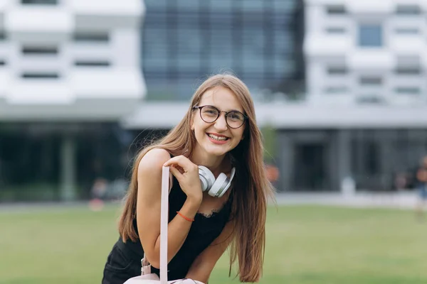 Γοητευτική φιλική γυναίκα με μακριά μαλλιά και πανέμορφο χαμόγελο φοράει κομψά γυαλιά με αληθινά χαρούμενα συναισθήματα στο δρόμο — Φωτογραφία Αρχείου