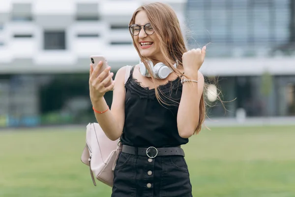 Fille ayant de bonnes nouvelles sur smartphone. Belle femme excitée au début des années 20 gagner quelque chose criant de joie et de célébrer — Photo