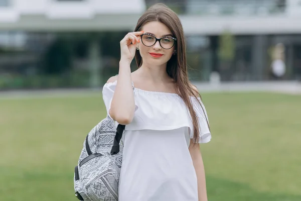 Młoda kobieta nosząca okulary. Piękna młoda dziewczyna w białej koszuli na ulicy w okularach — Zdjęcie stockowe