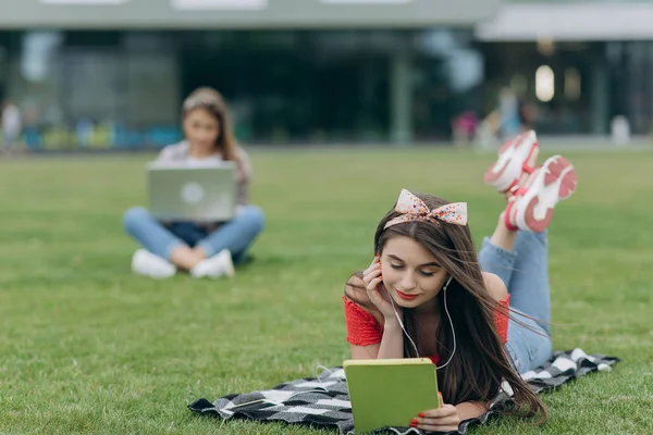 Młoda dziewczyna Hipster z laptopem siedzi w parku na trawniku. Dziewczyna odpoczywa na trawie. Pracuj na zewnątrz. Zrelaksuj się i bądź szczęśliwy. Nauka ucznia — Zdjęcie stockowe