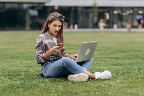 Woman using computer on green grasses in the park. freelance working outdoor or relaxation concept. — Stock Photo, Image
