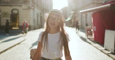 Avrupa'da seyahat çekici genç kadın ve Lviv güzel gezi keşfetmek, güneş lens parlama, yavaş hareket, hipster kız gözlük takıyor.