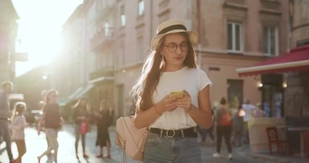 Kadın portresi. Sosyal ağlar, çevrimiçi olmak, internette gezinmek. Mesaj mesajları. Şehirde Yürüyen Güzel Genç Kadın. Cep telefonunu kullanıyor. Onunla sohbet ediyor. İleti Yazma — Stok video