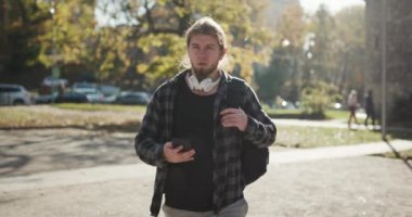 Genç adam sokakta yürürken telefonunu kullanıyor. Adam Smartphone 'unu kullanıyor. İlerici Teknoloji. Sosyal ağ. Seyahat yaşam tarzı. Telefonlar. Uygulamalar.