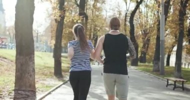 Genç adam ve kız spor yapıyor. Güneşli parkta koşan spor çifti. Spor eğitiminde erkek ve kadın birlikte. Atletik yeni evliler birlikte egzersiz yapıyorlar. Spor çifti parkta birlikte koşar..