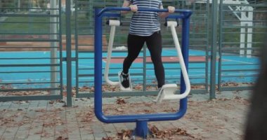 Kadınlar dışarıda egzersiz makineleriyle egzersiz yapıyorlar. Sağlık için egzersiz yaparak kilo verme kavramı