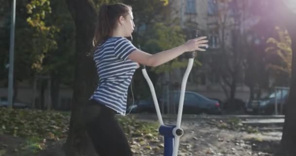 Sport- och fitnessträning utomhus. Aktivt livsstil och träningskoncept. Kvinna gör fitness träning på utomhus gym i parken. — Stockvideo