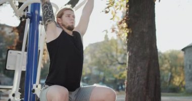 Sporcu Adam Eğitim Alanında. Fitness, spor, egzersiz, eğitim ve yaşam tarzı konsepti - açık havada barfiks çeken genç adam.