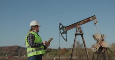 Enerji Endüstrisi İşadamı, Dijital Tablet Yağ Pompası Alanını Kullanıyor. Pumpjack Teknisyeni Dijital Tablet Kontrol Raporu Petrol Pompası Çiftliği İşi.