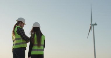 Enerji konsepti. İki mühendis enerji rüzgar çiftliği projesinden bahsediyor. İşçi Endüstri Ekibi Elektrik Üretim Faaliyetini Denetliyor