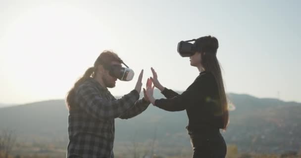 VR gözlük takan iki kişi. Genç yetişkin beyaz erkek ve dişi holografik artırılmış gerçeklik gözlüklerini birlikte kullanıyorlar.. — Stok video