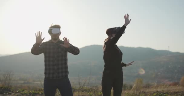 Bärtige Mann und Mädchen verwendet vr-Headset-Display mit Kopfhörern für Virtual-Reality-Spiel. zwei Personen verwendet vr Helm mit futuristischen visuellen Schnittstelle und berührt Droiden Hand — Stockvideo