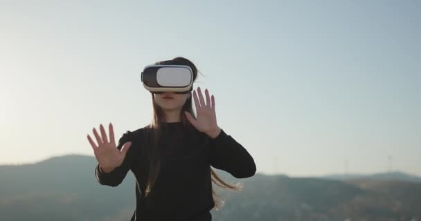 Mulher usando fones de ouvido de realidade virtual e olhando ao redor na exposição de tecnologia interativa. VR, realidade aumentada, arte digital, conceito futurista, interativo, imersivo e de entretenimento — Vídeo de Stock