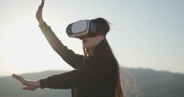 El futuro es ahora. Concepto VR. Mujer con auriculares futuristas VR box. mujer utiliza unas gafas de realidad virtual al aire libre. Chica en auriculares vr juego de aventura, entretenimiento juvenil, actividad de ocio — Vídeo de stock