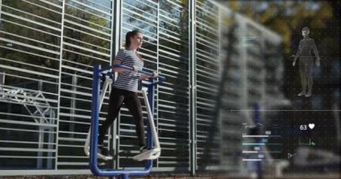 Çapraz çalıştırıcı kullanan genç bir kadın. Güneşli bir sabah, kız günlük spor yapıyor. Sağlıklı yaşam tarzı kavramı. Fütürist fitness takip uygulaması. Hologram görüntüsü