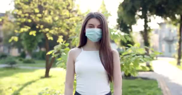 Egy fiatal nő portréja, aki védőmaszkot visel az utcai tömegben. Fogalom egészség és biztonság, N1H1 koronavírus karantén, vírusvédelem — Stock videók
