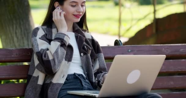 Jonge student kijkt online naar de les en studeert vanuit het park. Universiteitsstudent met laptop computer. Studeren werken met pc-technologie online onderwijs concept. — Stockvideo